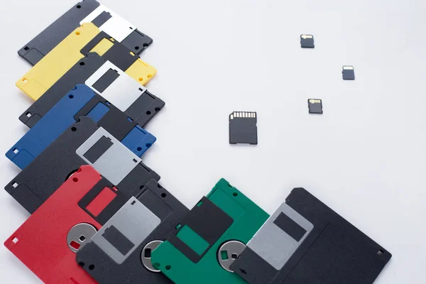 The evolution of digital data storage device. Floppy disks vs small memory cards. Isolated on a white background.