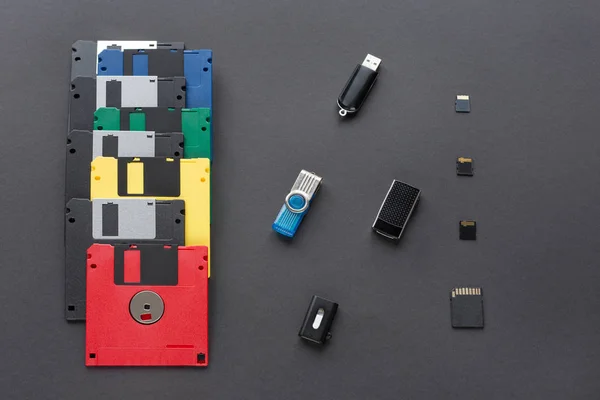 The evolution of digital data storage device. Floppy disks, flash drives and memory cards. Isolated on dark background.