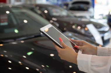 Bayi showroom dijital tablet kullanarak kadın satıcı. Dokunmatik ekran dijital tablet. Modern çalışma süreci.