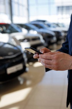 Bayi showroom iletişim için mobil akıllı telefon kullanan adam.