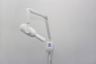 Beyaz bir arka planda izole diş kliniği X-ışını makinesi.