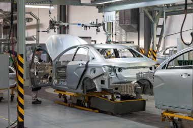 Rusya, Izhevsk - 15 Aralık 2018: Lada Otomobil Fabrikası Izhevsk. İşçiler yeni bir arabanın gövdesine kapı koydular..