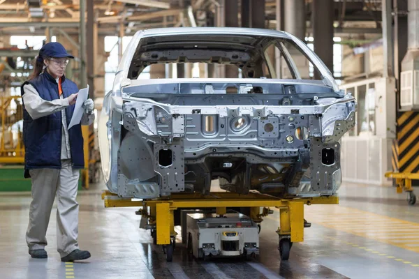 Rusia, Izhevsk - 15 de diciembre de 2018: LADA Automobile Plant Izhevsk. La trabajadora comprueba el cuerpo de un coche nuevo . — Foto de Stock