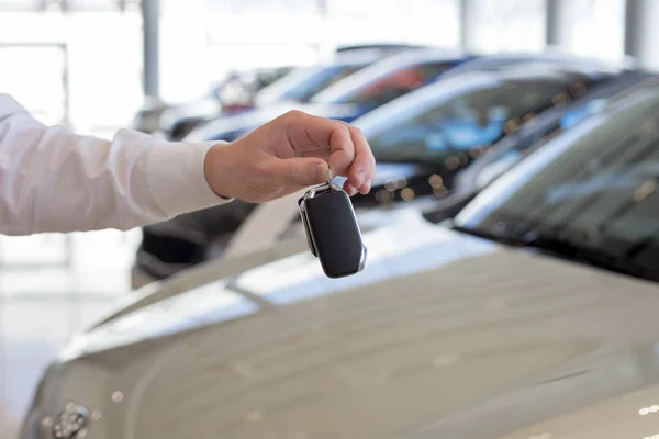 Dealer die sleutels aan een nieuwe auto vasthoudt. Moderne en prestigieuze voertuigen. — Stockfoto