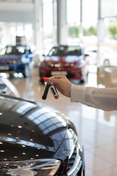 Händlerin mit Schlüsseln für ein neues Auto. moderne und prestigeträchtige Fahrzeuge. — Stockfoto