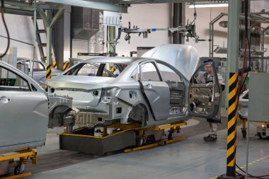 Rusya, Izhevsk - 15 Aralık 2018: Lada Otomobil Fabrikası Izhevsk. Kapıyı yeni bir arabanın gövdesine koy..
