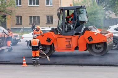Russia, Izhevsk - May 30, 2018: Road building. Repair and replacement of old asphalt pavement. clipart