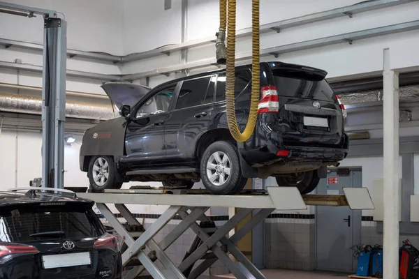 Rusya, Izhevsk - 20 Ekim 2018: Otomobil atölyesi. Onarım için hidrolik asansör üzerinde duran araba.