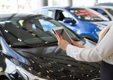 Satıcı showroom'da dijital tablet kullanan satıcı. Dokunmatik ekran dijital tablet. Modern çalışma süreci.