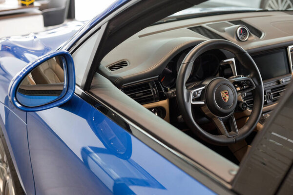 Россия, Ижевск - 04 августа 2020 года: выставочный зал Porsche. Руль и интерьер нового автомобиля Macan S. Известный мировой бренд.