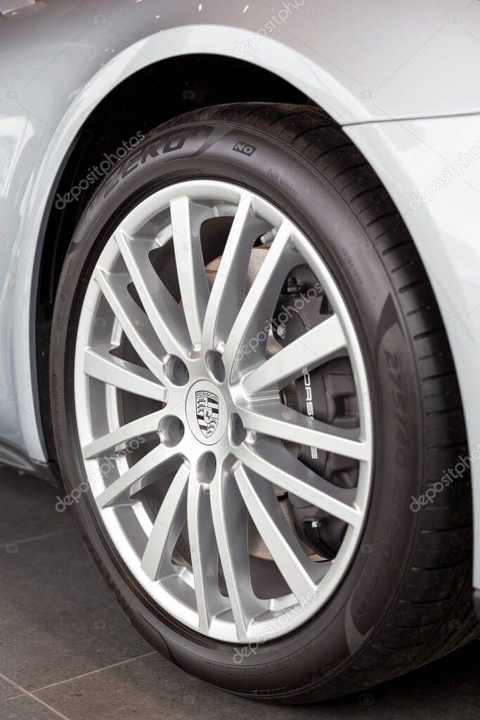 Russia, Izhevsk - August 04, 2020: Porsche showroom. The wheel with alloy wheel of a new Panamera 4 car. Famous world brand.