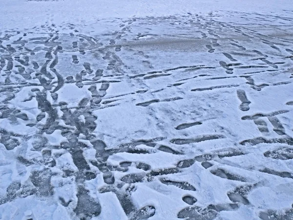 冬天冰冻的湖面上有许多人类脚印 — 图库照片