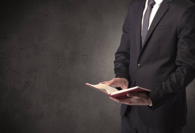 Elinde kitap tutan bir işadamı.