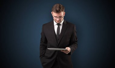 İşadamı holding tablet ile koyu arka plan