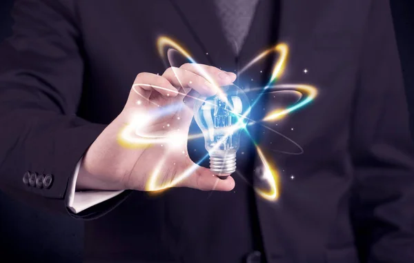 Businessman holding a colorful light bulb — Stock Photo, Image