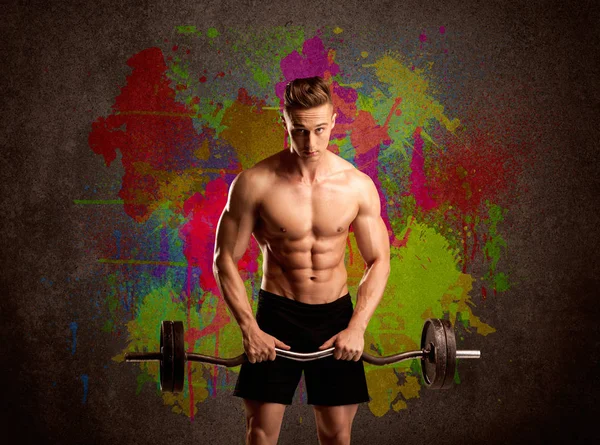 Strong guy with colorful paint wall and weight — Stock Photo, Image