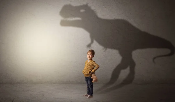 Dinosaurus skygger bak en søt gutt – stockfoto