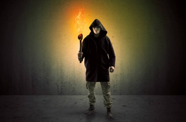Boş bir alanda flambeau yanma ile yürüyen adam