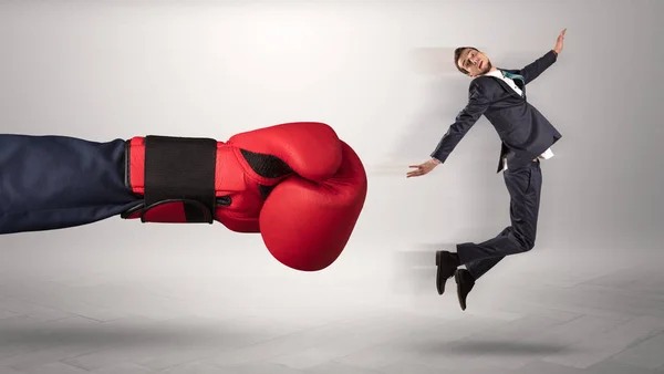 Giant hand gives a kick to a small businessman — Stock Photo, Image