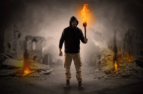 Man coming with burning flambeau at a catastrophe scene concept — Stock Photo, Image