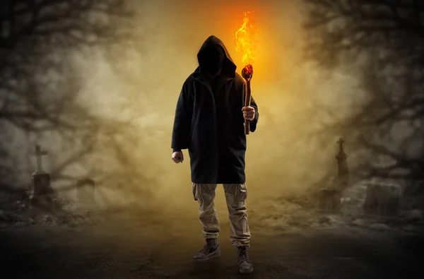 Man coming out from a thicket with burning flambeau — Stock Photo, Image