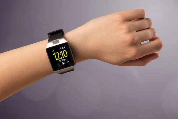 Female hand wearing and pressing smartwatch — Stock Photo, Image