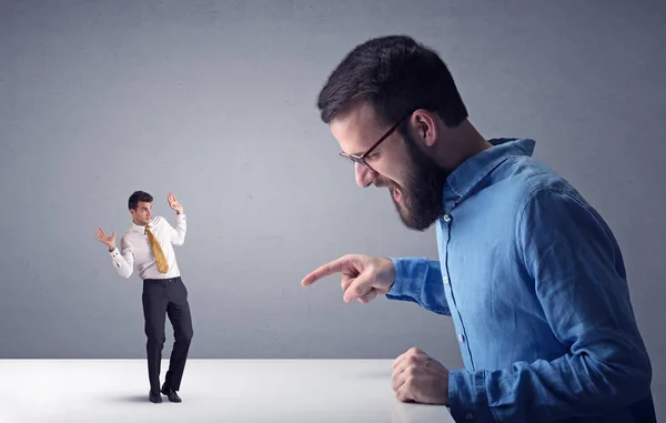 Joven hombre de negocios luchando con empresario en miniatura — Foto de Stock