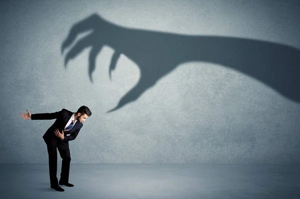 Persona de negocios con miedo de un gran concepto de sombra de garra monstruo — Foto de Stock
