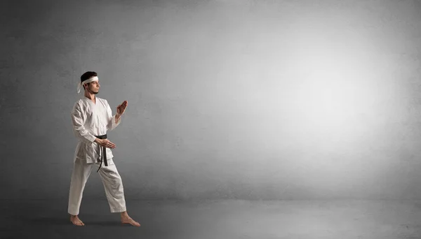 Kleiner Karate-Mann kämpft in einem leeren Raum — Stockfoto