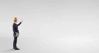 Boş bir alanda duran ve bir plan tutan mimar