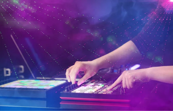 Mão misturando música no controlador midi com as cores do clube de festa ao redor — Fotografia de Stock
