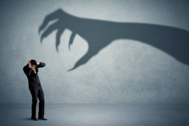İş kişi büyük canavar pençe gölge kavramı korkuyor