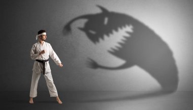 Karate man fighting with a big scary shadow clipart