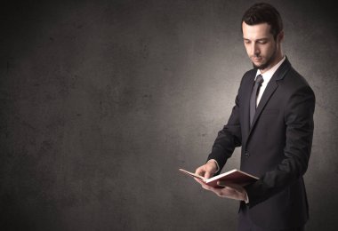 Elinde kitap tutan bir işadamı.