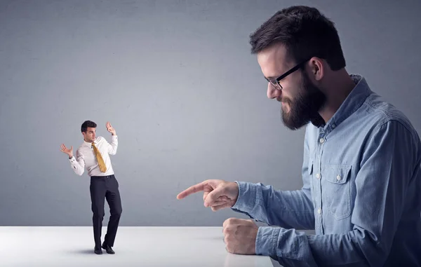 Joven hombre de negocios luchando con empresario en miniatura — Foto de Stock