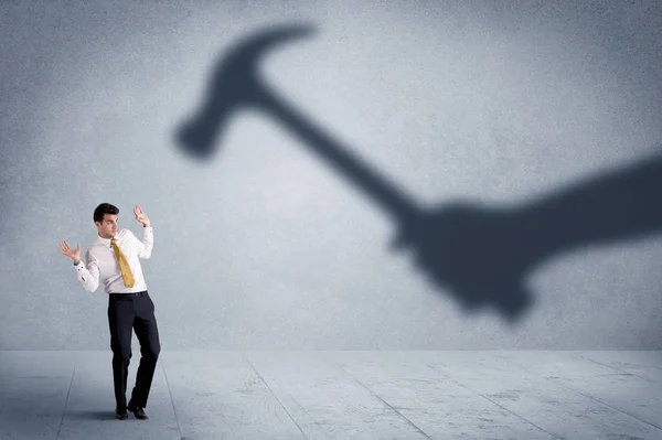 Business person afraid of a shadow hand holding hammer concept — Stock Photo, Image