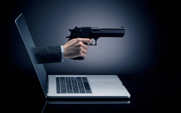 Ruka se zbraní vycházející z notebooku — Stock fotografie