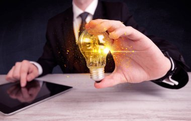 bir ampul tutarak ofis çalışanı