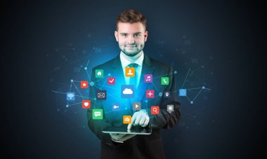 Onun el ve uygulama simgeleri yukarıdaki tablet ile takım elbiseli yakışıklı işadamı
