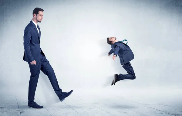 Big businessman kicking small businessman — Stock Photo, Image