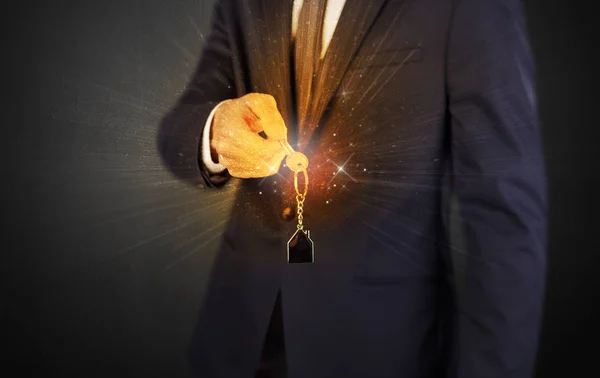 Man in suit hand over keys — Stock Photo, Image