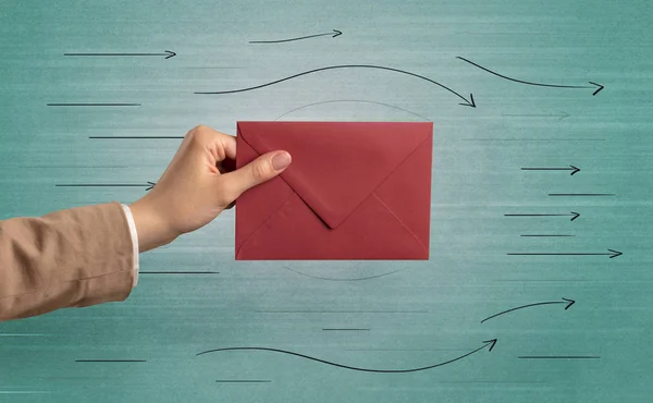 Hand holding envelope with arrows around — Stock Photo, Image