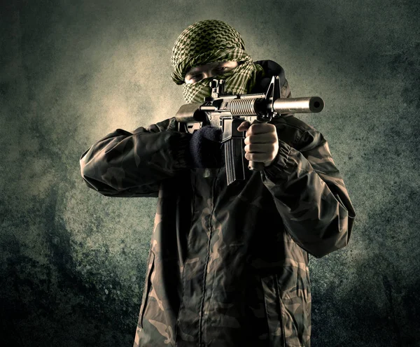 Portrait d'un soldat masqué lourdement armé avec un arrière-plan grognon — Photo
