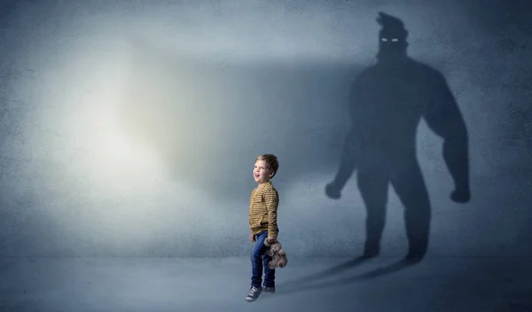Cute kid with hero shadow behind — Stock Photo, Image