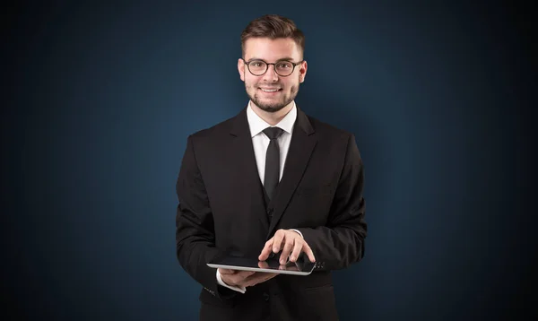 Businessman holding tablet with dark background