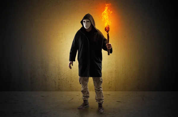 Man walking in an empty space with burning flambeau — Stock Photo, Image