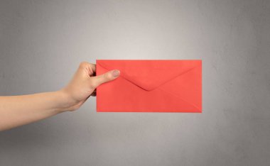 Zarf boş duvar arka plan ile tutan el