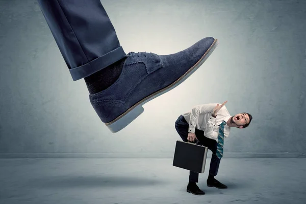 Angestellter wird von großem Schuh getreten — Stockfoto