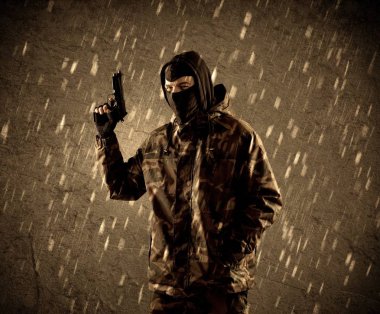 Tehlikeli ağır silahlı terörist asker maskesi grungy yağmurlu zemin üzerine 