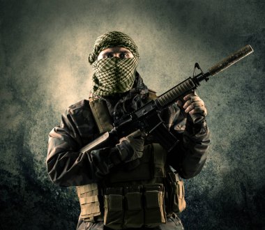 Eski arka plan kavramı ile ağır silahlı bir maskeli asker portresi